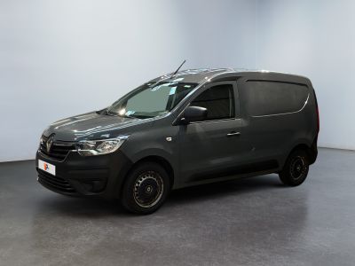 La camionnette grise est garée dans une pièce aux murs blancs.