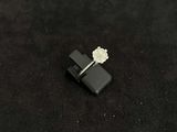 a small white flower sitting on top of a black object