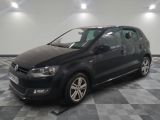 the black volkswagen polo is parked on a checkered tile floor