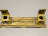 an antique brass plate with two candles on top of it