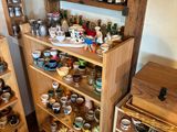 une étagère en bois remplie de tasses et de sauces dans une pièce
