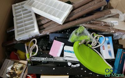 une boîte remplie d'objets divers, posée par terre