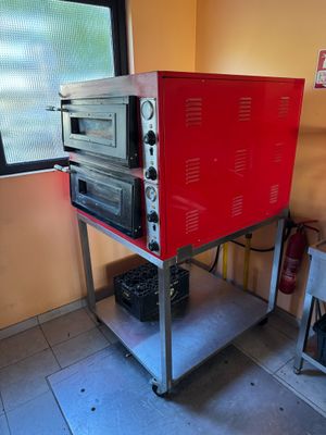 un four rouge posé sur un chariot en métal dans une cuisine