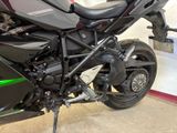 a black and green motorcycle parked in a garage