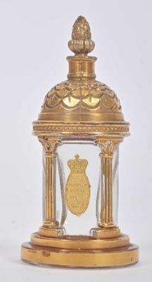 une horloge en or surmontée d'un dôme en verre