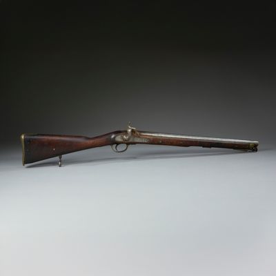 a rifle with a wooden barrel and brass fittings