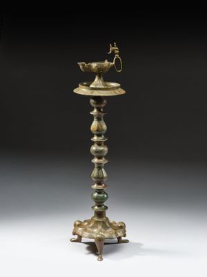 une vieille lampe en laiton surmontée d'un oiseau
