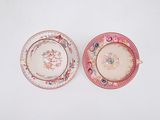 pair of pink and white plates with flowers on them on a white surface