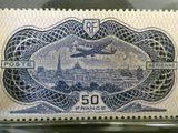 a close up of a stamp with a picture of a plane flying over a city