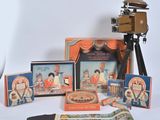 a camera and some pictures on a table next to a movie projector