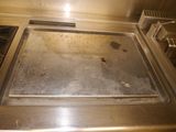 a dirty pan sitting on a stove top in a kitchen