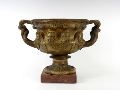 un grand vase en bronze posé sur un socle en marbre