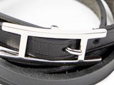 black leather bracelet with a silver buckle on a white surface