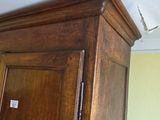 a wooden armoire in a room with a white ceiling