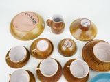 many cups and saucers sitting on a table