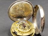 a silver and gold pocket watch with a chain around it