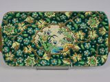 une assiette verte et dorée ornée de fleurs et d'oiseaux