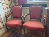 two red chairs in a room with a rug on the floor
