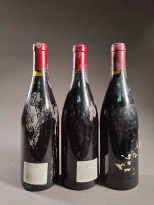 trois bouteilles de vin sont posées l'une à côté de l'autre sur une table
