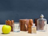an apple, a glass, a bottle, and a box on a table