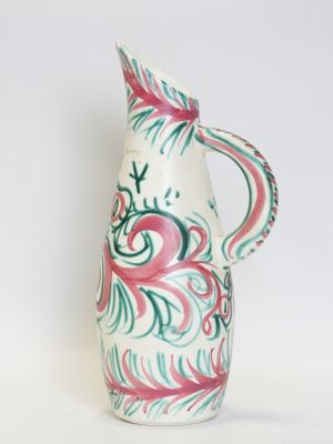 a white vase with a pink and green design on it
