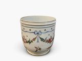 a white cup with a blue ribbon and flowers on it