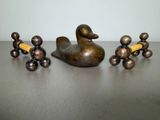 a statue of a duck and a group of candlesticks on a table