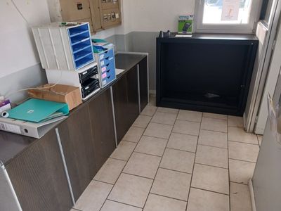 une petite cuisine équipée d'un réfrigérateur et d'une télévision