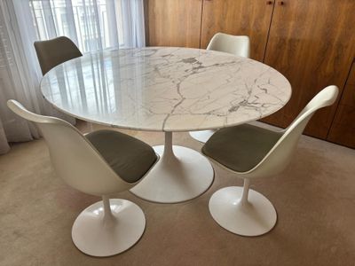 a marble dining table with four chairs around it