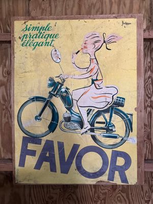 une affiche représentant une femme à moto accrochée au mur
