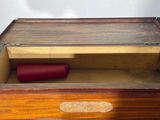 a wooden box with a red roll of paper inside of it