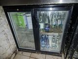 a refrigerator that has two bottles of beer inside of it