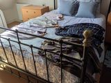 un lit avec un cadre en métal dans une chambre dotée d'une lucarne