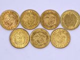 six different types of gold coins sitting on top of a white surface