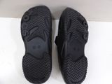 pair of black slippers on a white surface with a white background