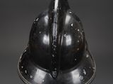 a black helmet on a stand against a gray background