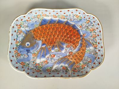 une assiette décorée d'un motif de poisson, posée sur une table