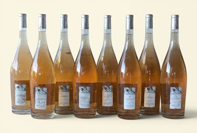 six bottles of wine are lined up in a row on a white surface