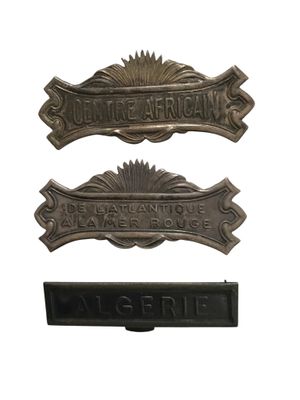 On voit trois panneaux métalliques sur un fond blanc.