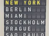 un panneau sur lequel on peut lire : Londres, Tokyo, New York, New York, Manhattan, Stockholm, Prague, Hong, Hong, Rio