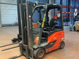 un chariot élévateur dans un entrepôt, avec des palettes au premier plan