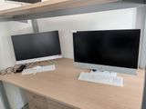 two computer monitors and a keyboard on a desk