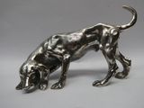 une statue en argent représentant un chien en train de manger quelque chose