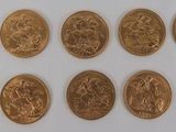 a close up of a bunch of gold coins on a white surface