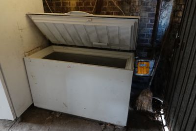 a white chest freezer sitting in the corner of a room