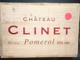 une boîte en bois sur laquelle est apposée une étiquette indiquant « Château Clinet »