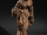 une statue représentant une femme tenant un panier de fleurs