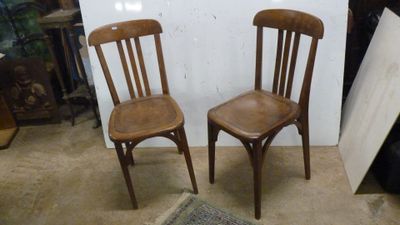 deux chaises en bois assises l'une à côté de l'autre dans une pièce