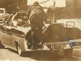 une vieille photo d'un homme à l'arrière d'une voiture
