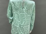 a mannequin mannequin wearing a green shirt and black pants